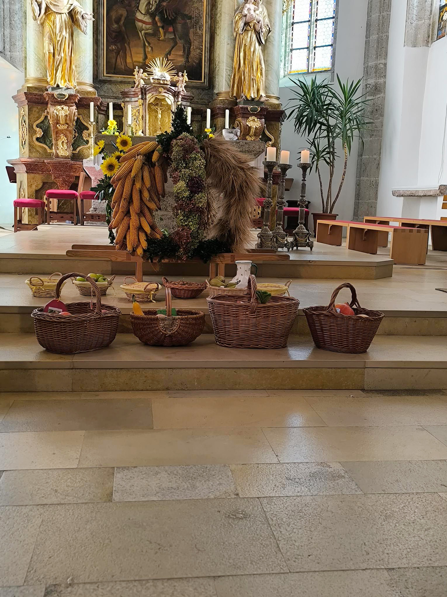 Die Erntegaben der Kindergartenkinder vor der Erntekrone vorm Altar