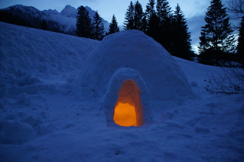 Iglu mit einer Kerze in der Abenddämmerung               